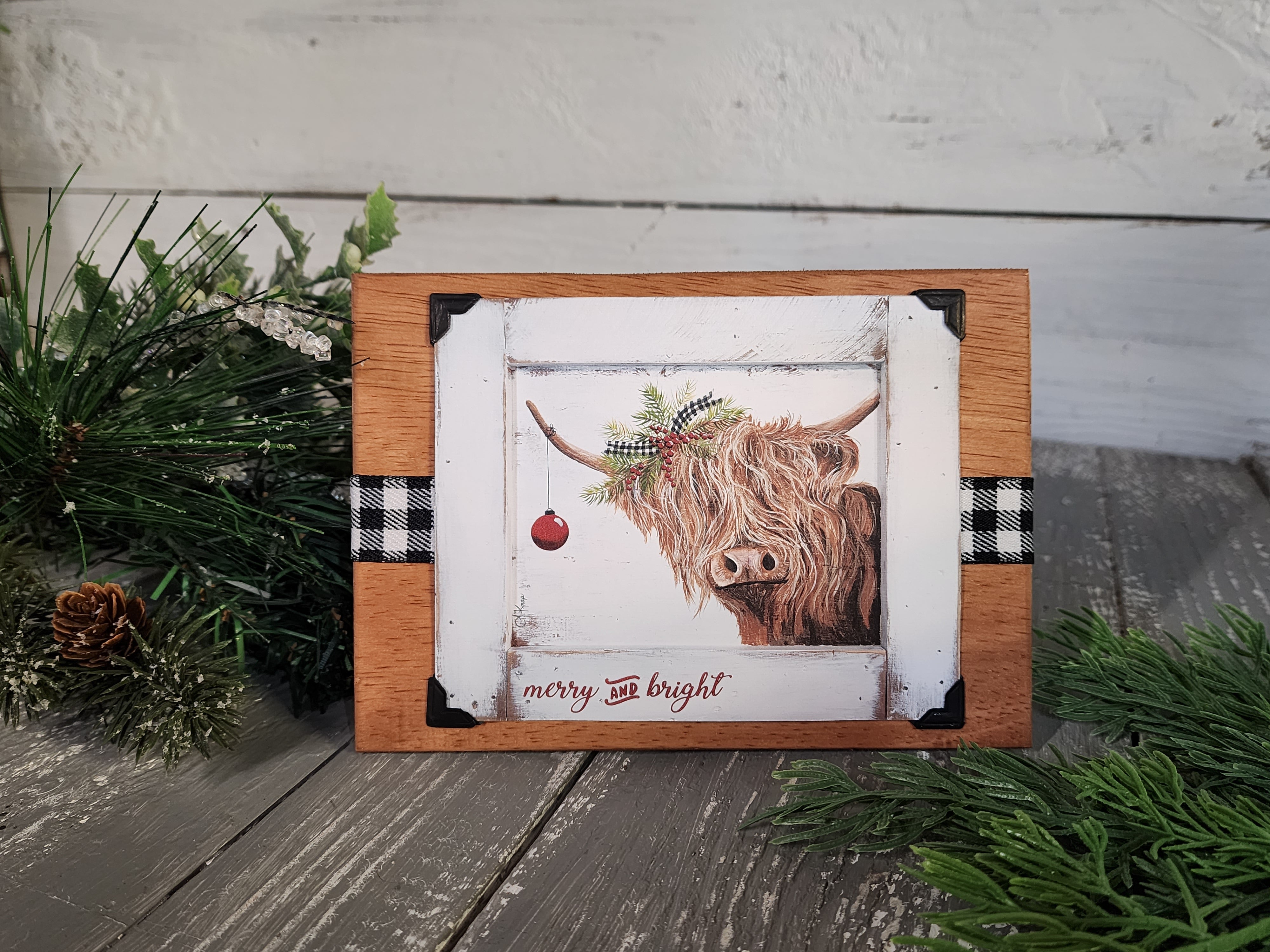 Wood Single Handmade Christmas card with black and white buffalo plaid ribbon, Highland cow with Christmas evergreens, attached stand
