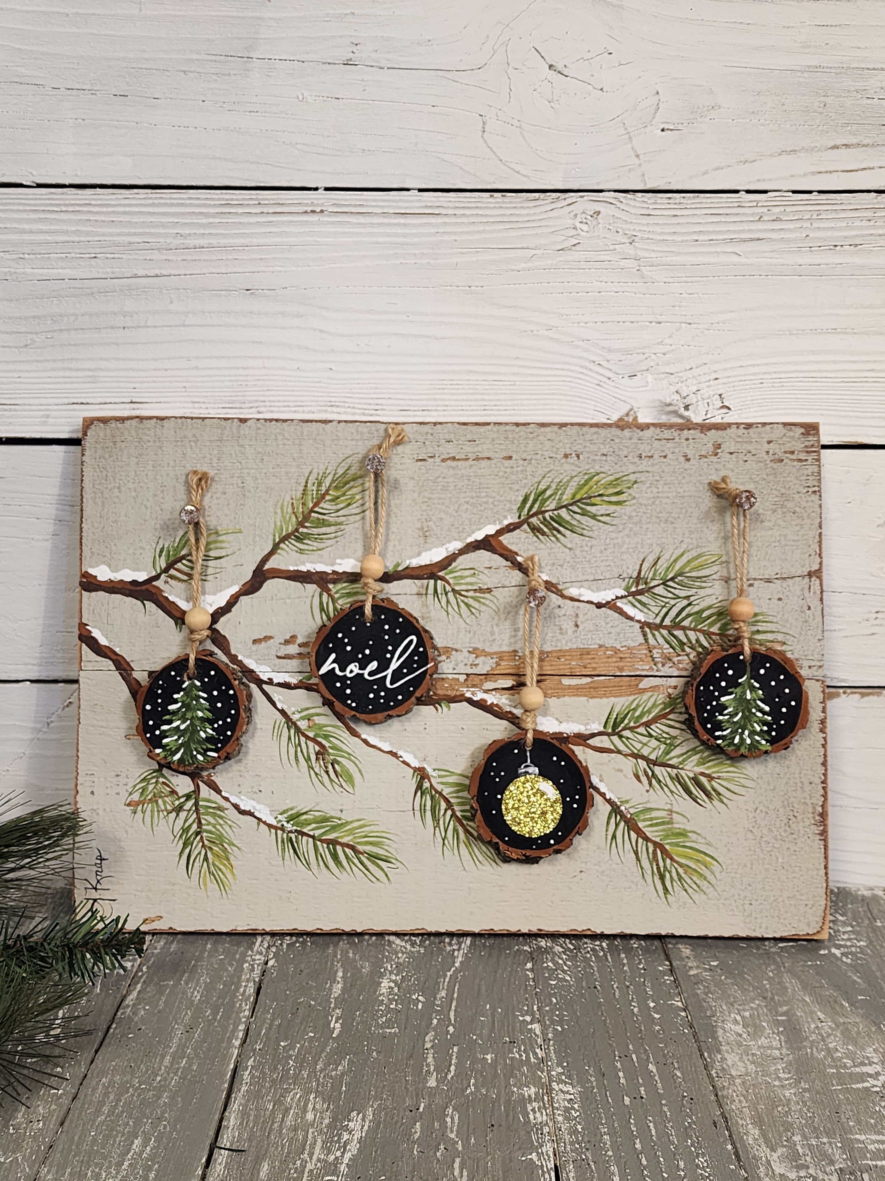 Noel Christmas handmade wood slice ornaments on snow covered pine tree branch, recycled holiday artwork, black and gold accents, tan antique