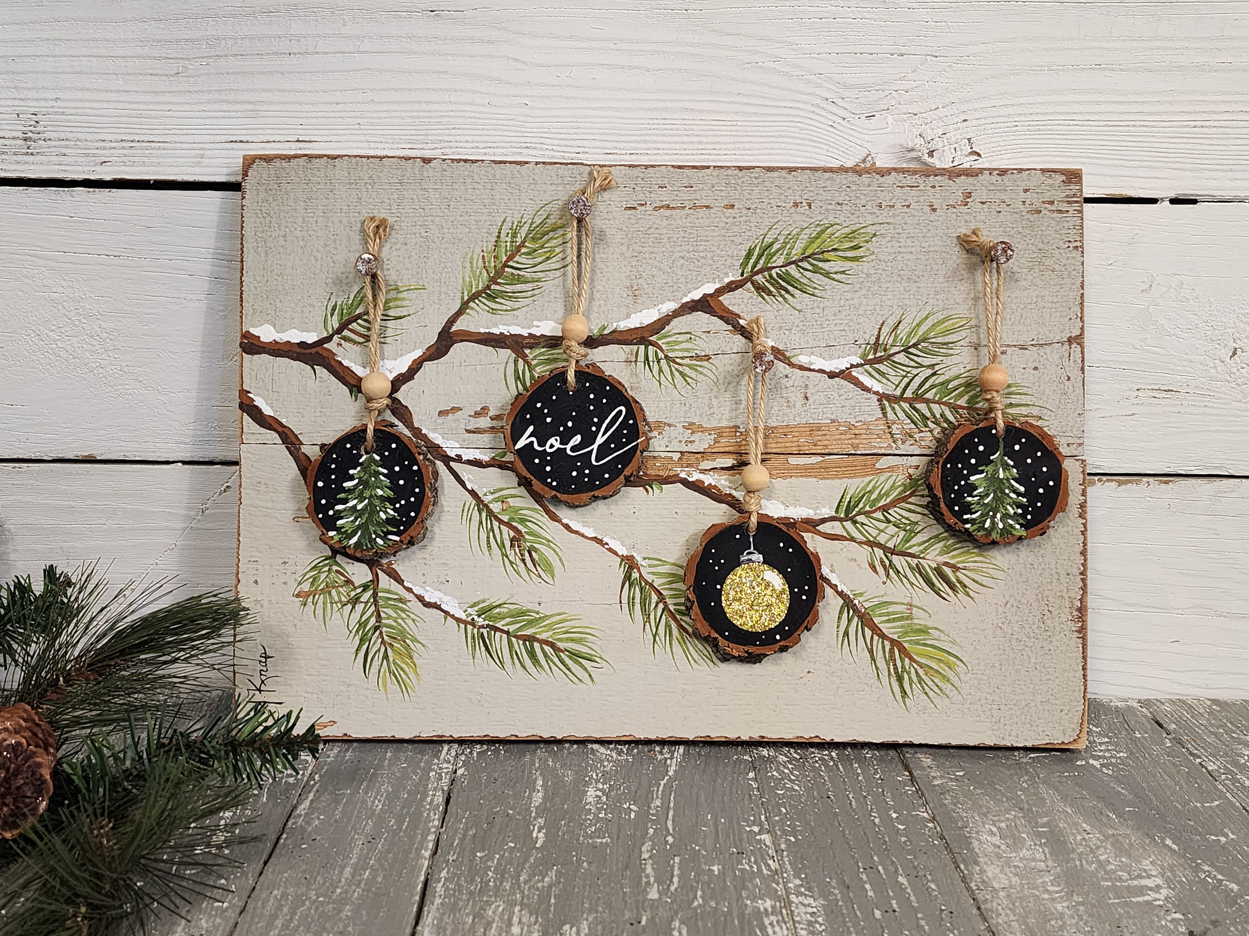 Noel Christmas handmade wood slice ornaments on snow covered pine tree branch, recycled holiday artwork, black and gold accents, tan antique