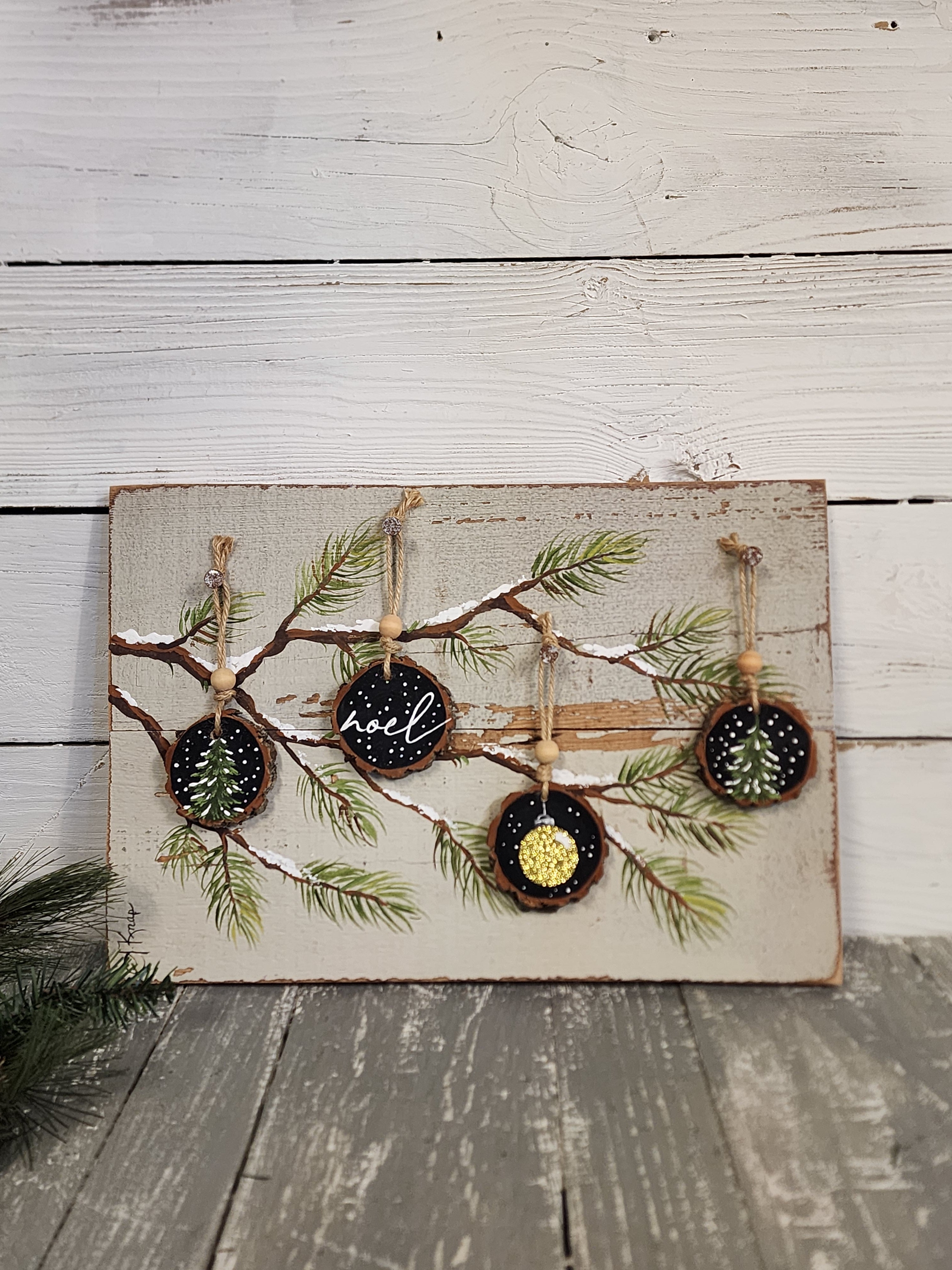 Noel Christmas handmade wood slice ornaments on snow covered pine tree branch, recycled holiday artwork, black and gold accents, tan antique
