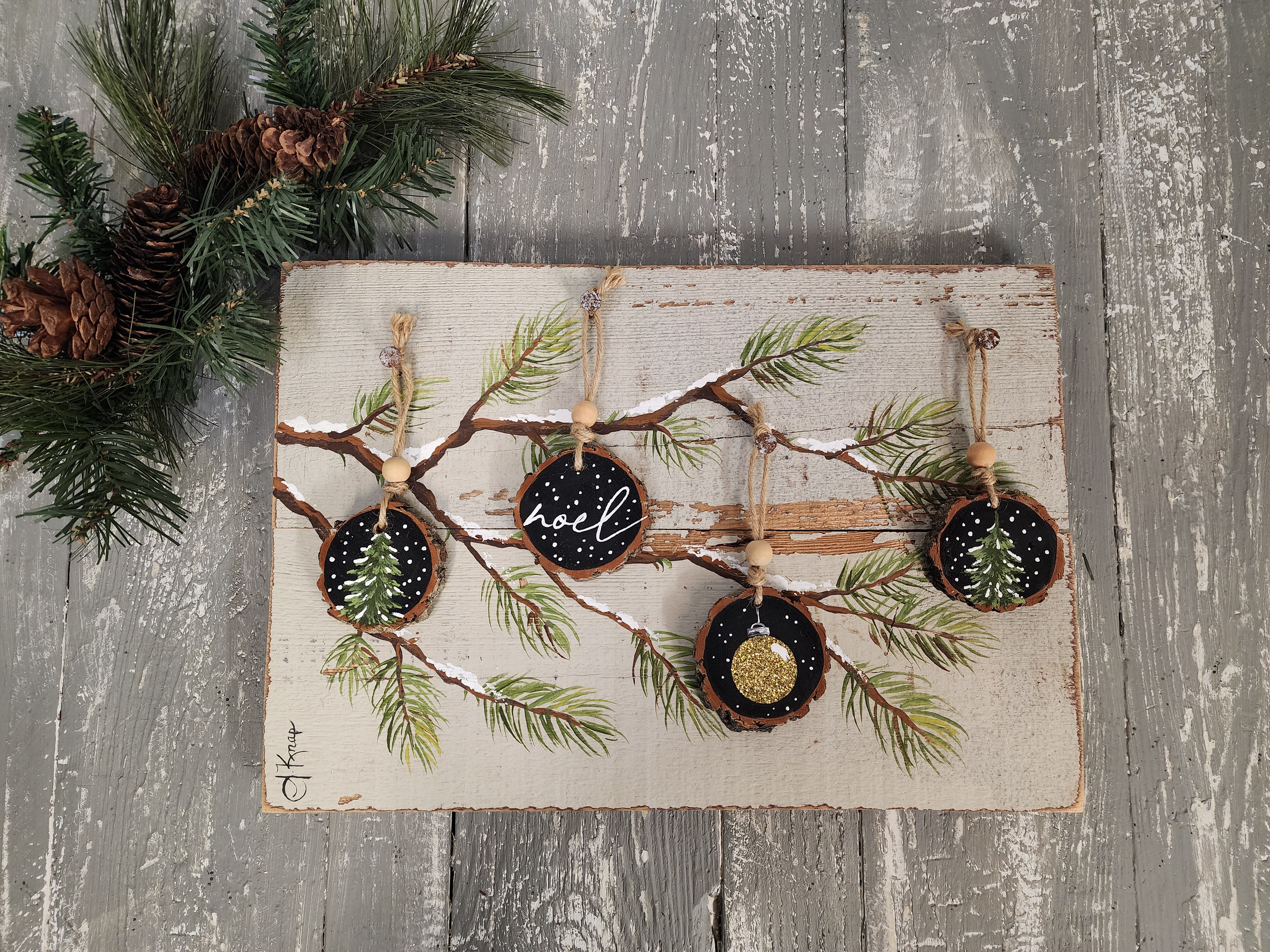 Noel Christmas handmade wood slice ornaments on snow covered pine tree branch, recycled holiday artwork, black and gold accents, tan antique