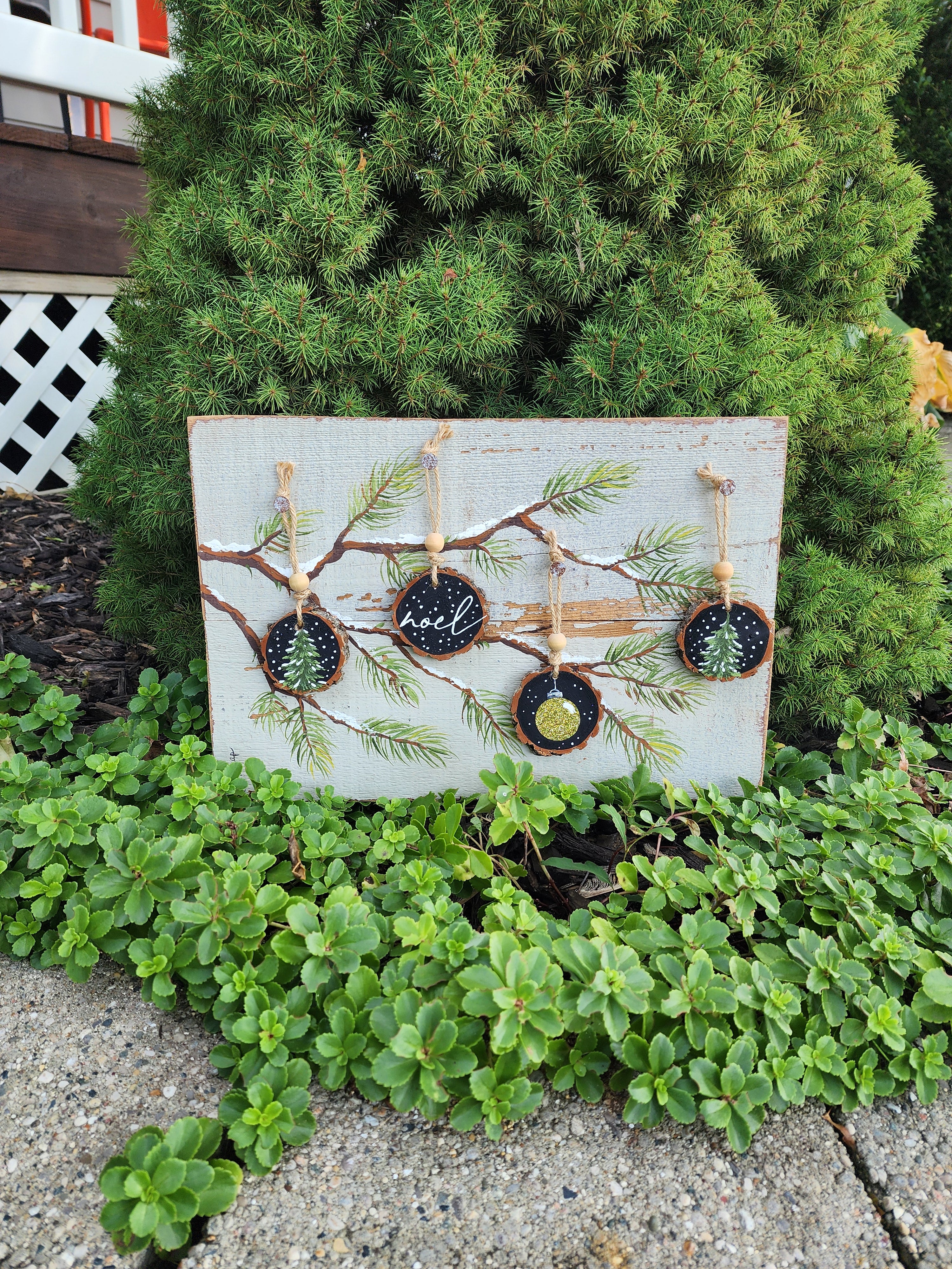 Noel Christmas handmade wood slice ornaments on snow covered pine tree branch, recycled holiday artwork, black and gold accents, tan antique