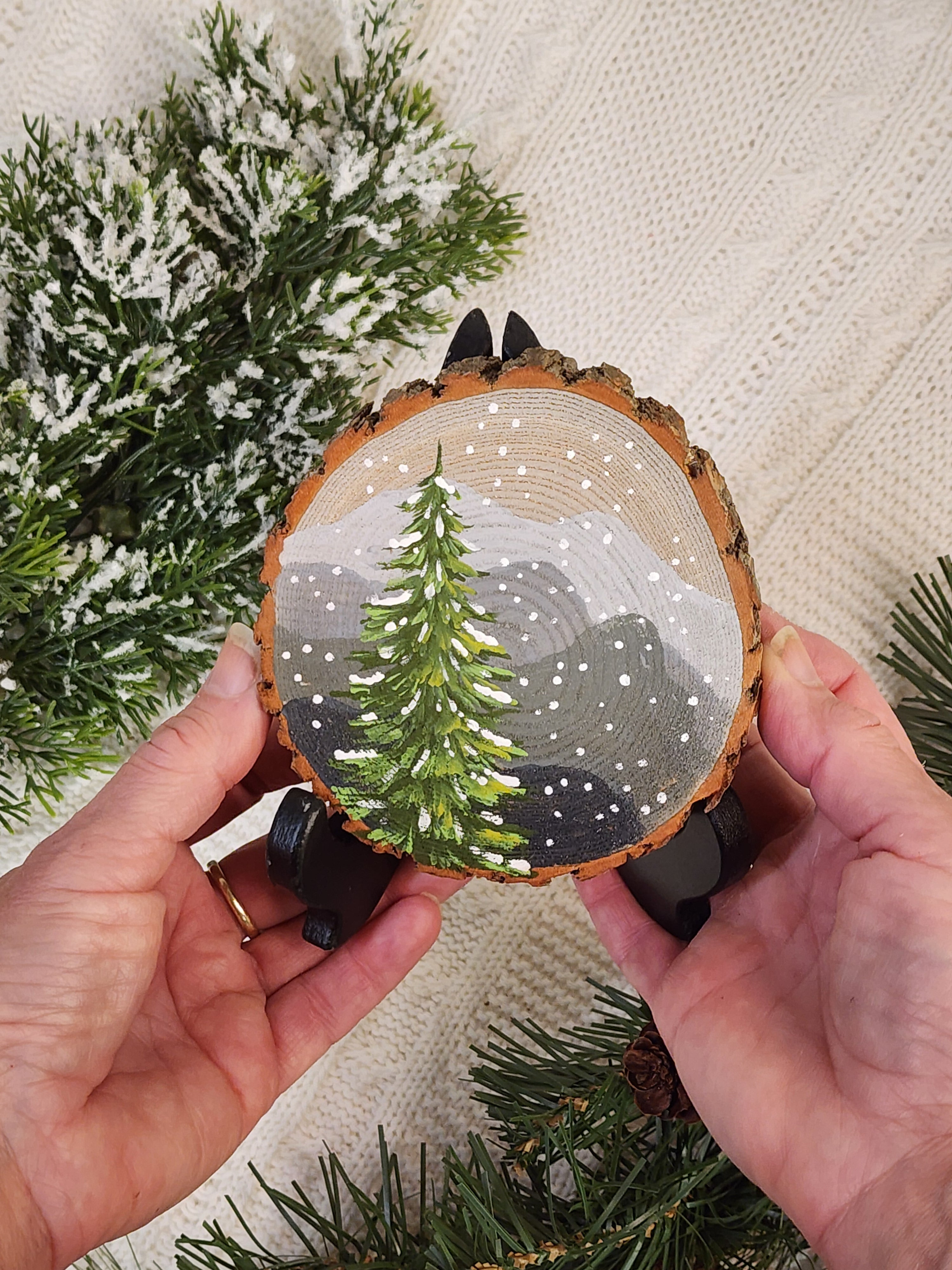 Large Hand Painted Christmas snowy mountain artwork on hand cut wood slice, snow-covered pine tree, includes black frame stand