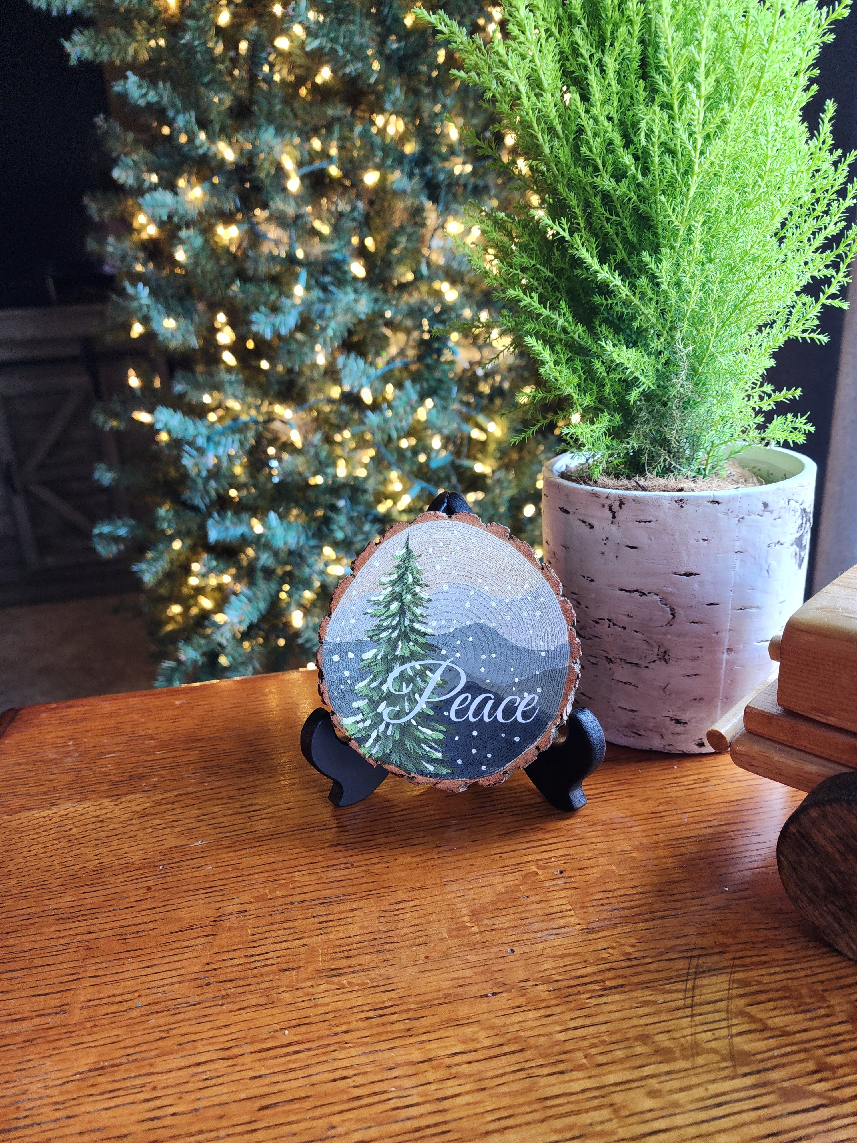 Large Hand Painted Christmas snowy mountain artwork on hand cut wood slice, snow-covered pine tree, includes black frame stand, Peace