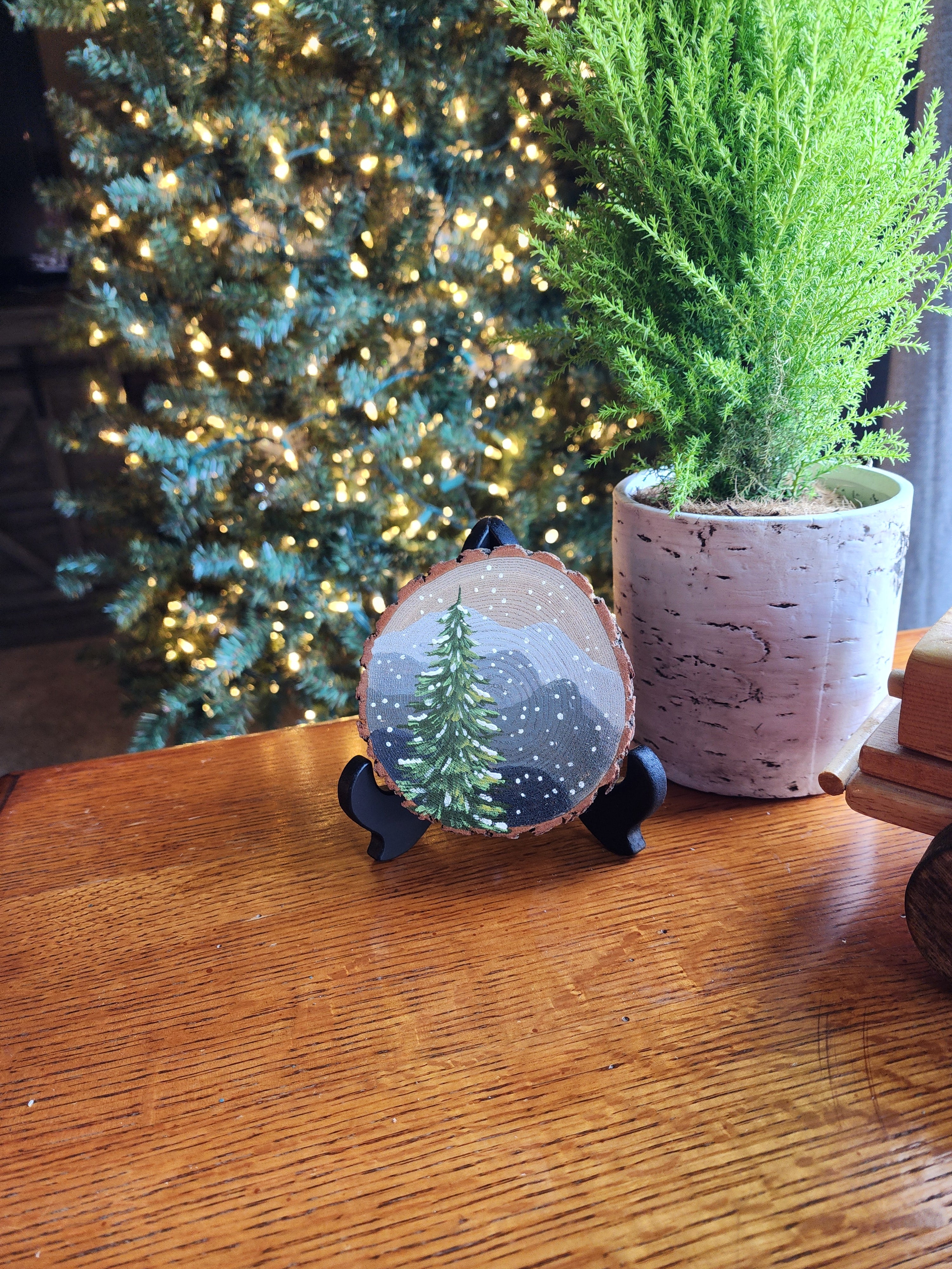 Large Hand Painted Christmas snowy mountain artwork on hand cut wood slice, snow-covered pine tree, includes black frame stand